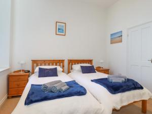 two beds in a bedroom with blue towels on them at 2 Bell Tower in Penzance
