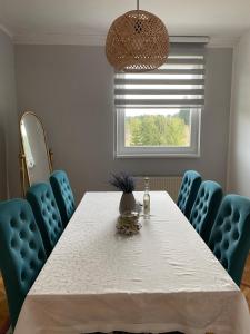 a dining room with a white table and blue chairs at Viola 144 in Han Pijesak +18 photos