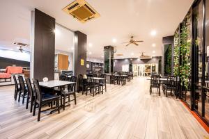 パタヤ・セントラルにあるDancenter Luxury Underwater World Pattayaのレストラン内のテーブルと椅子のあるダイニングルーム