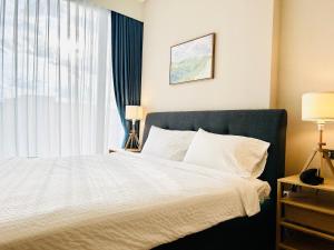 een slaapkamer met een wit bed en een raam bij Wyndham Garden Sukhumvit 42 in Bangkok