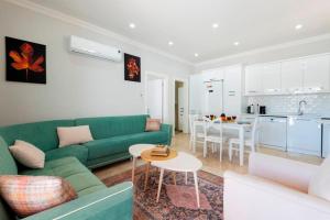 ein Wohnzimmer mit einer grünen Couch und einer Küche in der Unterkunft Villa Zafar - Private outdoor pool in Kaş