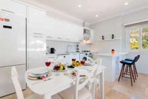 eine weiße Küche mit einem weißen Tisch und Stühlen in der Unterkunft Villa Zafar - Private outdoor pool in Kaş