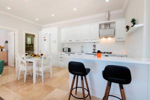 eine Küche mit weißen Schränken und einem Tisch und Stühlen in der Unterkunft Villa Zafar - Private outdoor pool in Kaş