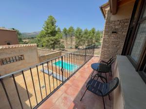 a balcony with two chairs and a swimming pool at Cal Gabarró - Casa para 12 con piscina, WiFi, AC y BBQ in Vilanova de Meyá