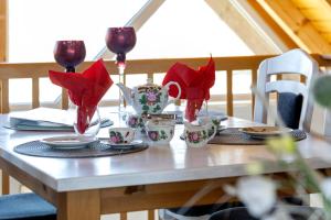 a table with red napkins and glasses on it at Ferienhaus Harmonie in Südbrookmerland