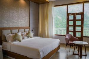 a bedroom with a bed and a large window at The TeaTree Munnar in Suryanelli +141 photos