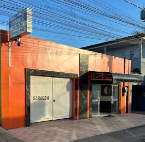 an orange building with a garage on the side of it at Hotel São Cristóvão in Marabá