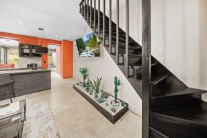 a kitchen and living room with a staircase with plants at Maison d'architecte avec Jacuzzi, Quartier Prémontrés in Pont-à-Mousson