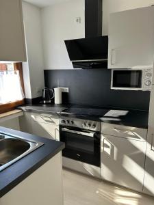 a kitchen with a stainless steel stove and a sink at RheinSchatz Apartments 3 in Oberwesel +6 photos