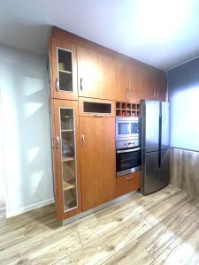 a kitchen with wooden cabinets and a refrigerator at LM apartamentos Alfacar in Alfacar