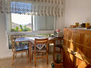a kitchen with a table and chairs and a window at חדר בדירה במצפה רמון in Mitzpe Ramon +3 photos