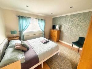 a bedroom with a bed and a window and a chair at 2 Bed House - Sleeps 4 - Parking - Pets - Garden in Doncaster