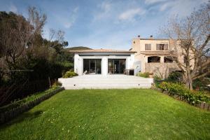 una casa con un gran césped delante de ella en Casa Olâ House, en Luri