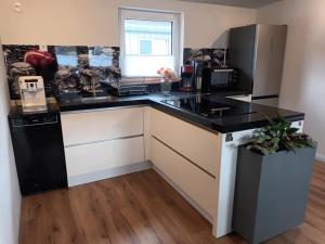 a kitchen with a black and white counter top at Fabians Ferienhaus - 4 besondere Ferienwohnungen in Simmerath