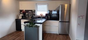 a kitchen with a stainless steel refrigerator and appliances at Fabians Ferienhaus - 4 besondere Ferienwohnungen in Simmerath