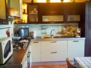 y cocina con microondas y fregadero. en Piazzetta Lago, en Cannobio