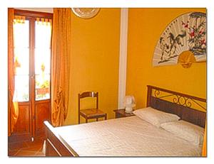 Un dormitorio con una cama, una silla y una ventana en Piazzetta Lago, en Cannobio