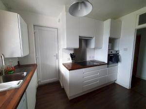 eine weiße Küche mit weißen Schränken und einer Spüle in der Unterkunft 2 Bedroom, free parking & Netflix near hospitals in Aberdeen