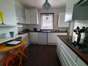 eine Küche mit weißen Schränken, einem Tisch und einer Theke in der Unterkunft 2 Bedroom, free parking & Netflix near hospitals in Aberdeen + 4 Fotos