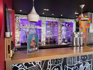 a bar with a wall covered in graffiti at ibis Cambrai in Cambrai