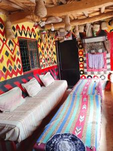 ein großes Bett in einem Zimmer mit einer farbenfrohen Wand in der Unterkunft gite Imouzar in Iabassene