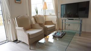 a living room with two chairs and a glass table at Park Welgelegen, MB 27 in Cadzand