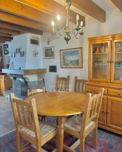a dining room with a wooden table and a fireplace at Maison Opaline in Le Touquet-Paris-Plage