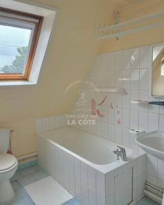 a bathroom with a tub and a toilet and a sink at Maison Opaline in Le Touquet-Paris-Plage