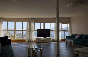 a living room with a couch and a flat screen tv at Mountain Zen 2 Bed Ultimate Retreat with BBQ & Pool in Masāfī