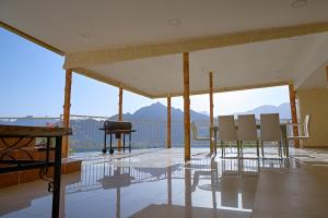 a room with chairs and a grill on a balcony at Mountain Zen 2 Bed Ultimate Retreat with BBQ & Pool in Masāfī +11 photos