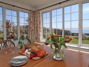 a dining room table with a vase of flowers on it at Watchtower in Torpoint
