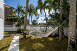una hamaca en un patio trasero con palmeras en Chopin #102, en Fort Lauderdale 3 fotos más