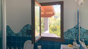 a bathroom with a window and a toilet in it at Vista mare montagna da Marcello in Cala Gonone +22 photos