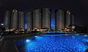 Mactan IslandにあるCosy Nest Royal Oceancrest Mactanの建物の前に青い照明が付く大型スイミングプール