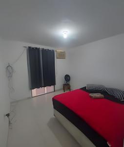 une chambre avec un lit avec une couverture rouge dans l'établissement lindo apartamento recreio dos bandeirantes, à Rio de Janeiro