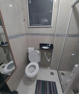 une petite salle de bain avec toilettes et miroir dans l'établissement lindo apartamento recreio dos bandeirantes, à Rio de Janeiro