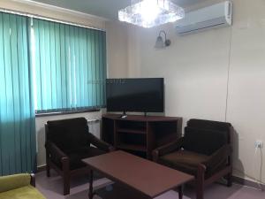 a living room with two chairs and a flat screen tv at Hotel Korona Хотел Корона in Debelets