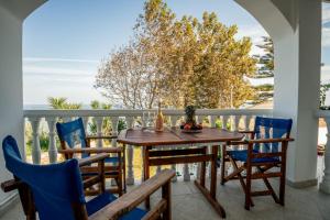 a table and chairs on a balcony with a view of the ocean at Vikos Seaside Apartments in Kypseli