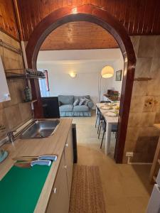a kitchen with a sink and a living room at La casetta di Tato in Monterosso al Mare