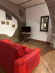 a living room with a red couch and a television at Estia Bed and Relax in Benevento