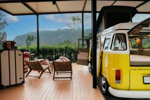 Ban Sathani Bandai MaMarasca Khao Yai - Eco-friendly Glamping Escape Near National Park的一辆黄色和白色的面包车,配有两把椅子和一张桌子 更多37张照片