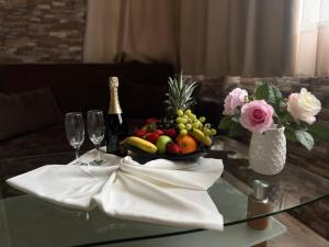 a table with a bowl of fruit and a bottle of champagne at Family Hotel Gallery - Sunny Beach in Sunny Beach