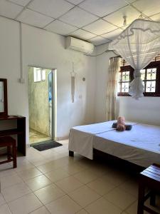 une chambre avec un grand lit dans une pièce dans l'établissement Coco Mango Hostel, à Dikwella