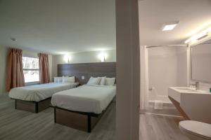 a hotel room with two beds and a bathroom at Viking Shores Motor Inn in Eastham +20 photos