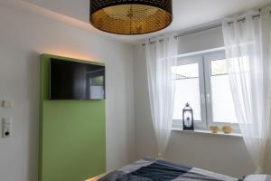 TV a/nebo společenská místnost v ubytování Ferienwohnung Sonnenstrahl am Harkebrügger See mit Sauna