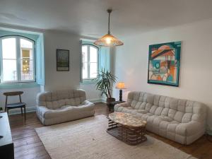 Una sala de estar con dos sofás y una mesa. en Casa da Heidi, en Lourinhã