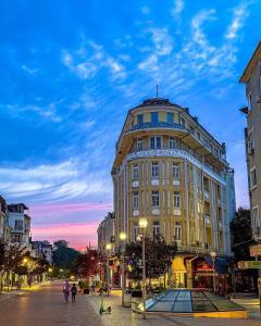 a large building on a city street at dusk at Apartment Musala N 05 in Varna City
