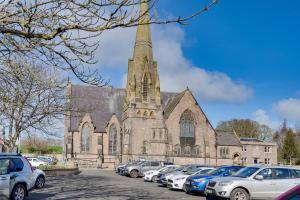 eine Kirche mit Autos auf einem Parkplatz in der Unterkunft NEW The Procession Grade II Listed and Pet Friendly in Berwick-Upon-Tweed