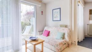 a living room with a couch and a table at Appartement confortable à Vaux-sur-Mer - 40 m² + terrasse in Vaux-sur-Mer