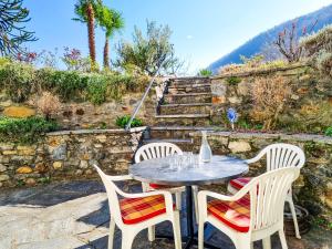 a table and three chairs sitting on a patio at Piccola Casa in Cannobio